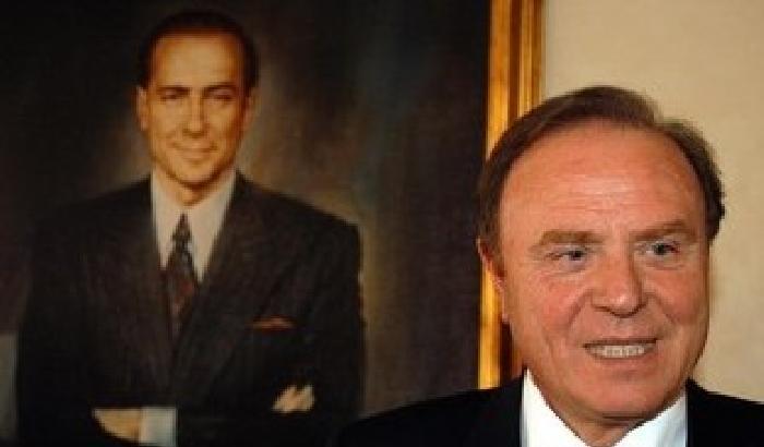 Ennio Dorsi davanti ad un ritratto di Berlusconi