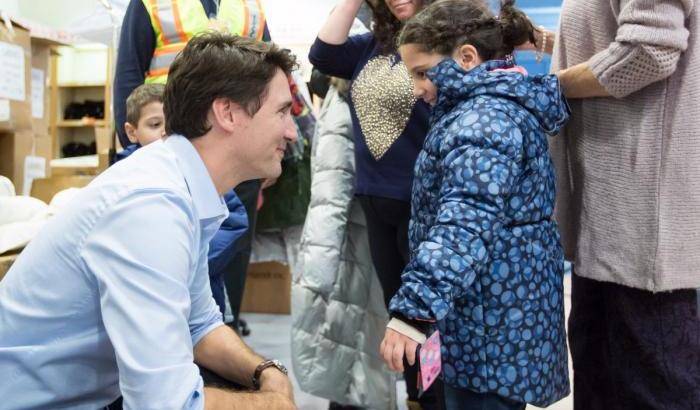 Justin Trudeau saluta una bambina siriana