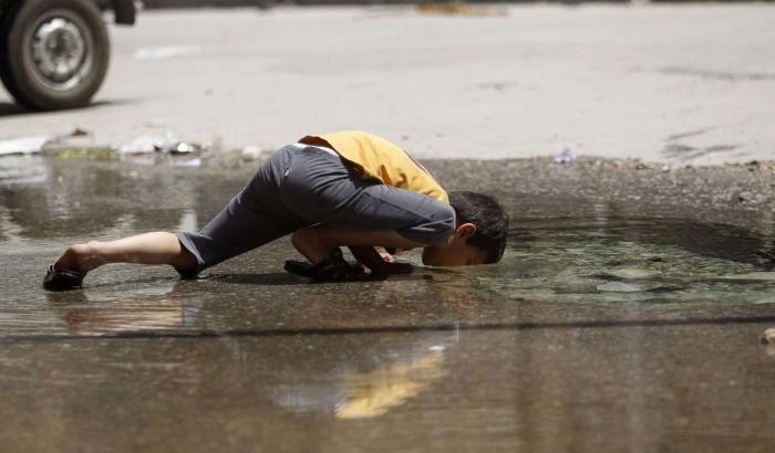 0005204D-un-bimbo-beve-da-una-pozzanghera-ad-aleppo Un bimbo beve da una pozzanghera ad Aleppo