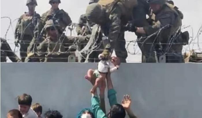 Bambino sopra il filo spinato dato ai militari
