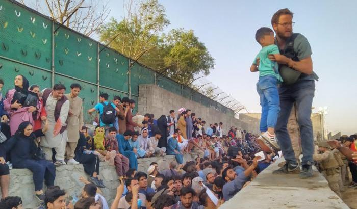 Il Console italian, Tommaso Claudi, mentre aiuta un bambino all'aeroporto di Kabul